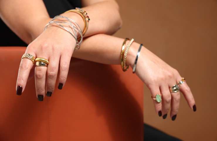 donna che indossa tanti bracciali e anelli