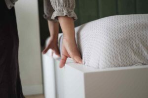 mani che rifanno il letto