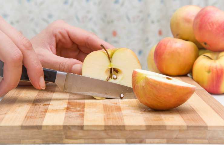 Coltello che taglia delle mele rosse